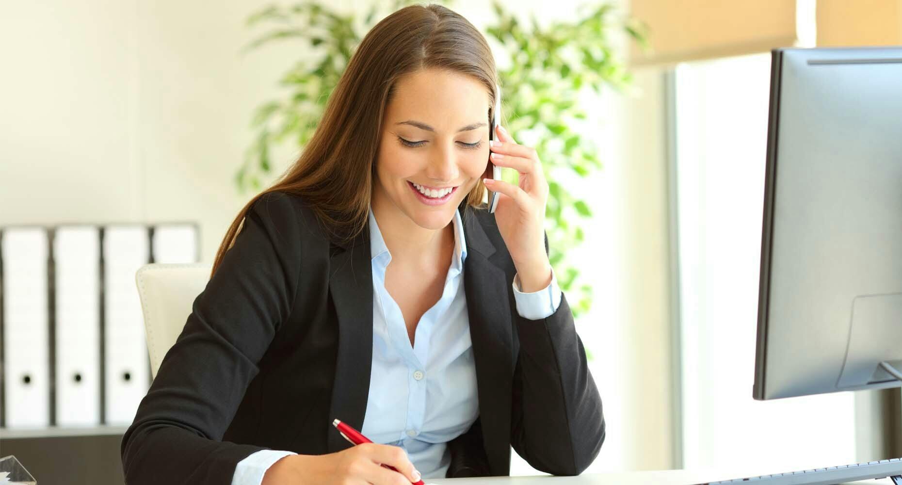 Sales woman taking notes while on a call