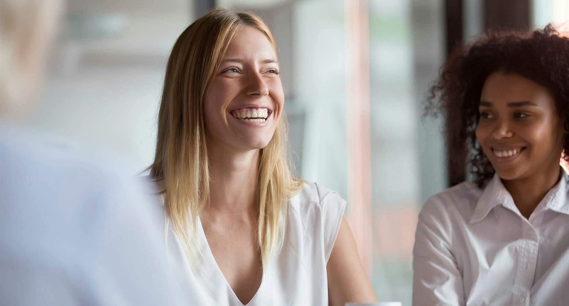 Two women smiling during a meeting