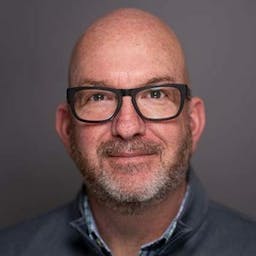 headshot of bald man with glasses